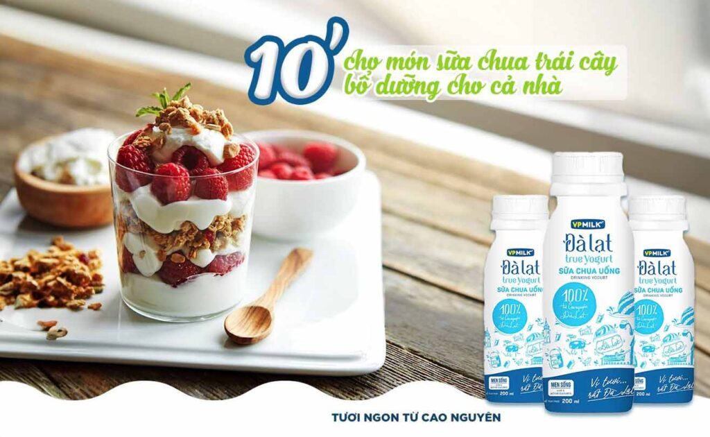 sữa chua uống đà lạt true yogurt cùng 1 ly sữa chua trộn trái cây trên bàn gỗ. Hình ảnh hấp dẫn